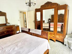 a bedroom with a bed and a dresser and a mirror at A casa della nonna in Imola