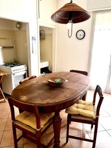 a kitchen with a wooden table with chairs and a clock at A casa della nonna in Imola
