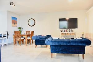 ein Wohnzimmer mit zwei blauen Sofas und einem Tisch in der Unterkunft KB's Beach House in Langstrand