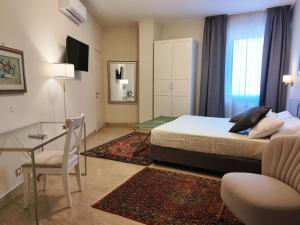 a bedroom with a bed and a table and a desk at Hotel Minerva in Ravenna +49 photos