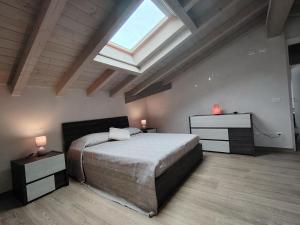 a bedroom with a large bed and a skylight at Sole e Luna nella Vigna in Villanuova sul clisi