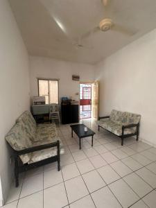 a living room with two couches and a table at Sweet home Beverly hills in Penampang