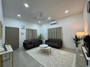 a living room with two couches and a table at Harees Homestay in Kuala Lipis