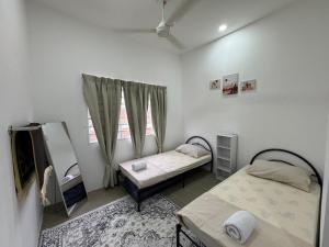 a bedroom with two beds and a window at Harees Homestay in Kuala Lipis