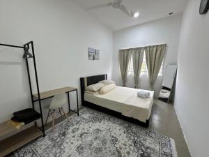 a bedroom with a bed and a table and a window at Harees Homestay in Kuala Lipis