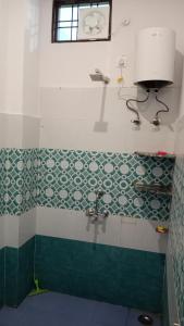 DevaprayāgにあるKrishna Hotel & Restaurantの緑と白のタイルの床と洗面台のあるバスルーム