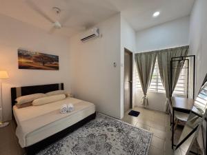 a bedroom with a bed and a table and a desk at Harees Homestay in Kuala Lipis