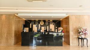 Un vestíbulo con relojes en la pared y flores. en Yasmin Hotel Karawaci, en Tangerang