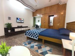 a bedroom with a large blue bed in a room at Flickstays Elara in Bangalore