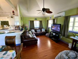 sala de estar con sofá y TV y cocina en Eco Friendly Secluded OceanView Pool near Key West, en Cudjoe Key