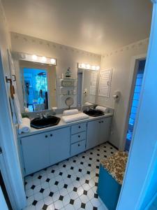 Un baño con dos lavabos y un espejo grande. en Eco Friendly Secluded OceanView Pool near Key West, en Cudjoe Key