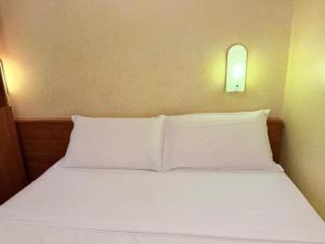 ein Bett mit weißen Laken und Kissen in einem Zimmer in der Unterkunft Hotel Bruna in Rom