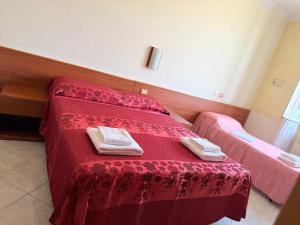 ein Schlafzimmer mit einem roten Bett mit zwei Handtüchern darauf in der Unterkunft Hotel Bruna in Rom + 7 Fotos