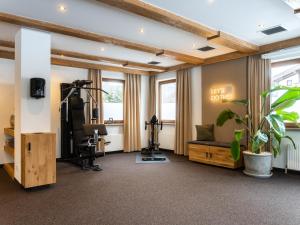 a fitness room with a treadmill and a gym at Hotel Hubertus in Lofer