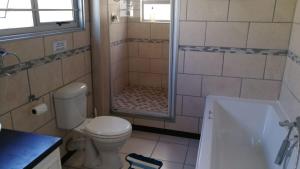 a bathroom with a shower with a toilet and a tub at Christmas Rock, East London in Christmas Vale