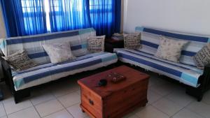 a living room with two couches and a table at Christmas Rock, East London in Christmas Vale