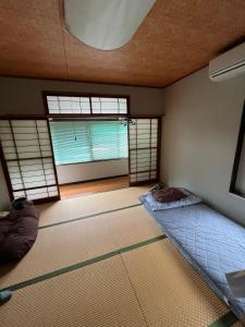 Ένα ή περισσότερα κρεβάτια σε δωμάτιο στο 民泊 シェアハウス北浦