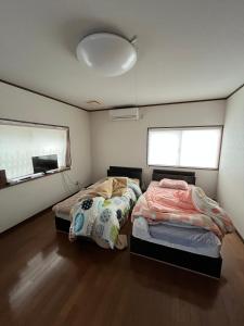 Ένα ή περισσότερα κρεβάτια σε δωμάτιο στο 民泊 シェアハウス北浦