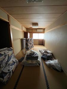 Ένα ή περισσότερα κρεβάτια σε δωμάτιο στο 民泊 シェアハウス北浦