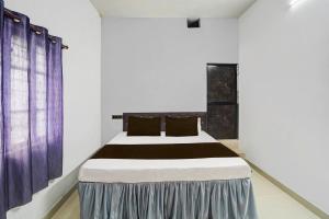 een slaapkamer met een groot bed met paarse gordijnen bij Hotel O Dream Star in Bhilai