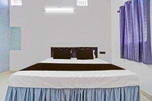 een slaapkamer met een groot bed met paarse gordijnen bij Hotel O Dream Star in Bhilai