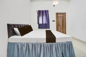een groot bed in een kamer met een paars gordijn bij Hotel O Dream Star in Bhilai +23 foto's