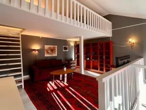 a living room with a red couch and a table at Centrally-located Unique Private apartment with 3 floors in Smedjebacken