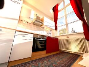 a kitchen with white appliances and a large window at Centrally-located Unique Private apartment with 3 floors in Smedjebacken +10 photos