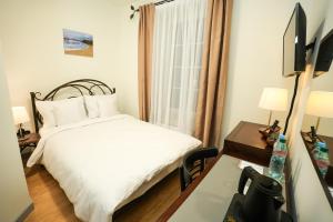 a small bedroom with a bed and a window at Villa Admiral in Gdynia