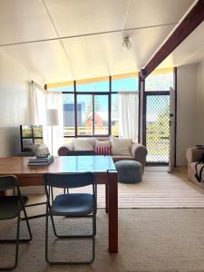 a living room with a table and a couch at Marlins Beach Shack Broulee in Broulee