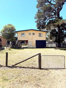 a house with a fence in front of it at Marlins Beach Shack Broulee in Broulee +3 photos
