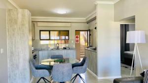 a kitchen with a table and chairs in a room at Sun-Ash Sea Gardens in Port Shepstone +3 photos