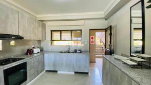 a large kitchen with a sink and a stove at Sun-Ash Sea Gardens in Port Shepstone
