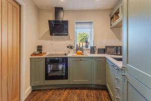 BrauncewellにあるHorse Ginのキッチン(緑のキャビネット、シンク付)