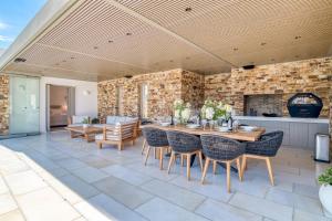 an outdoor patio with a wooden table and chairs at Villa Raphael - Luxury and Serenity in Paros in Naousa