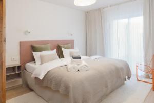 a bedroom with a bed with two towels on it at Design-Apartment am Chiemsee in Rimsting