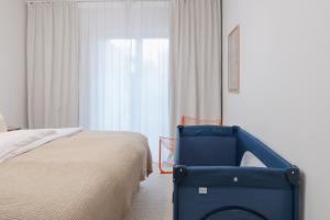 a bedroom with a blue chair next to a bed at Design-Apartment am Chiemsee in Rimsting