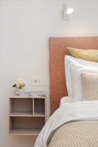 a bedroom with a bed with a nightstand next to it at Design-Apartment am Chiemsee in Rimsting