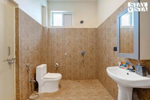 a bathroom with a toilet and a sink at StayVista at Casa Shwika with Pool and Lawn in Hyderabad +23 photos
