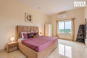 a bedroom with a large bed and a window at StayVista at Casa Shwika with Pool and Lawn in Hyderabad