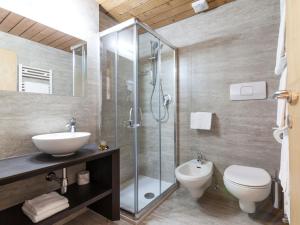 a bathroom with a toilet a sink and a shower at Hotel Casa Alpina - Alpin Haus in Selva di Val Gardena