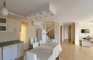 una cucina e un soggiorno con tavolo e sedie di Villa Mevsim a Kaş