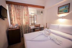 Una habitación de hotel con una cama con una toalla encima. en Cleopatra Hotel, en Asuán