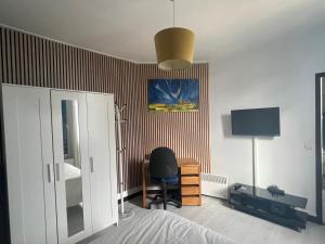 a bedroom with a bed and a desk and a chair at Studio cosy proche de Paris in Ermont