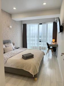 Un dormitorio con una cama grande con un escritorio y un escritorio. en RentNow Ultracentral Modern Apartment, en Chişinău