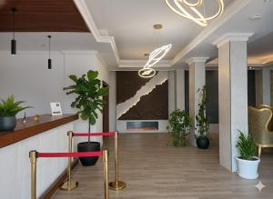 un vestíbulo con macetas y una pintura en la pared en Makran Palace Hotel, en Ma‘ābīlah