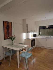 cocina con mesa y sillas y cocina con fregadero en modern apartment close to the airport, en Tromsø