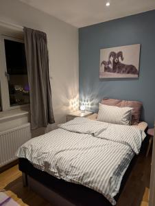 1 dormitorio con 1 cama con edredón a rayas en modern apartment close to the airport, en Tromsø