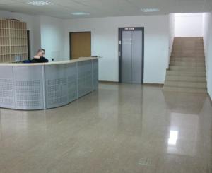 un hombre sentado en un escritorio en una habitación vacía en Uninova Hostel, en Bratislava