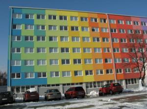 un gran edificio con coches estacionados frente a él en Uninova Hostel, en Bratislava